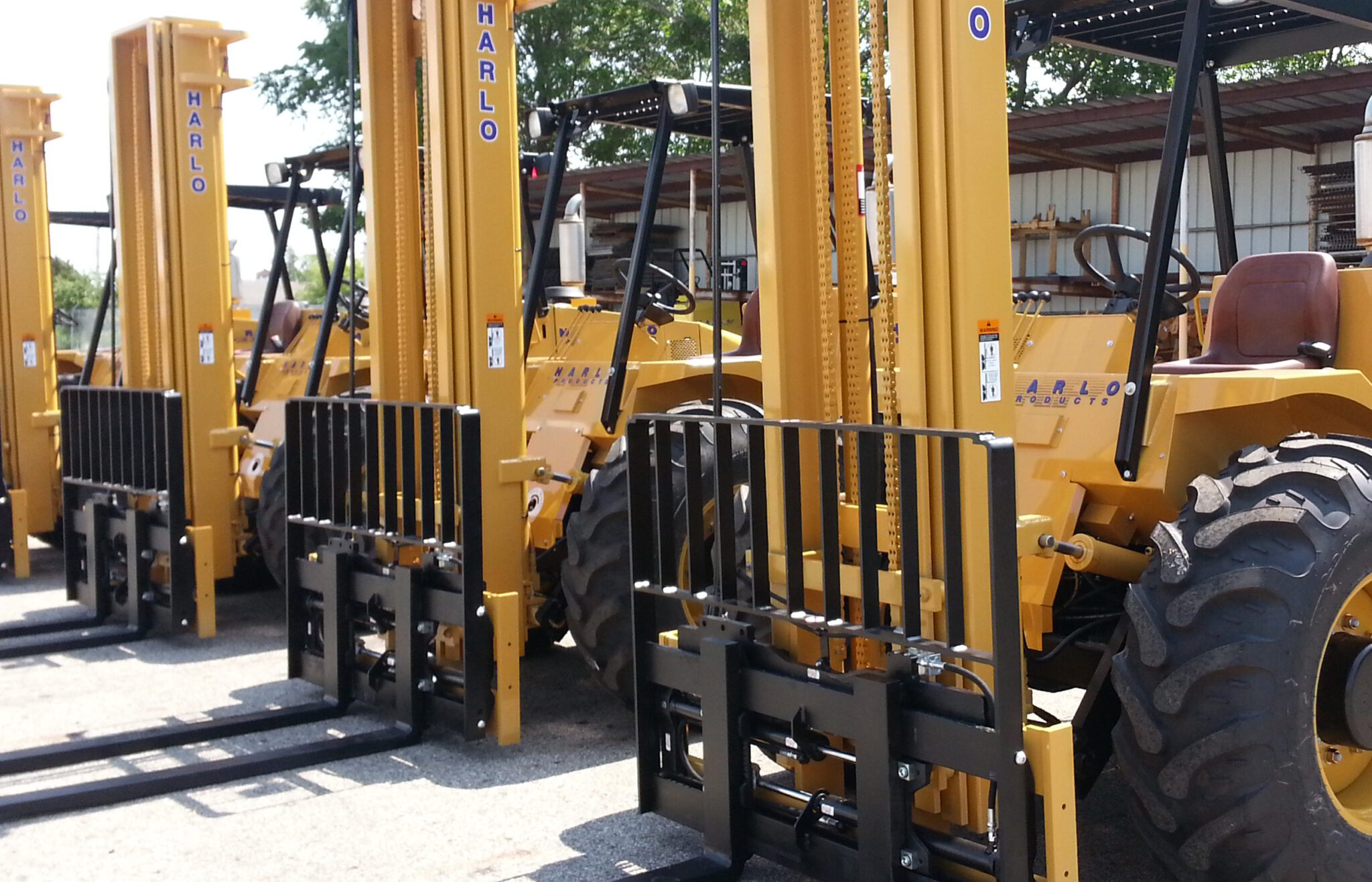 Row of Harlo rough terrain forklifts available for rental