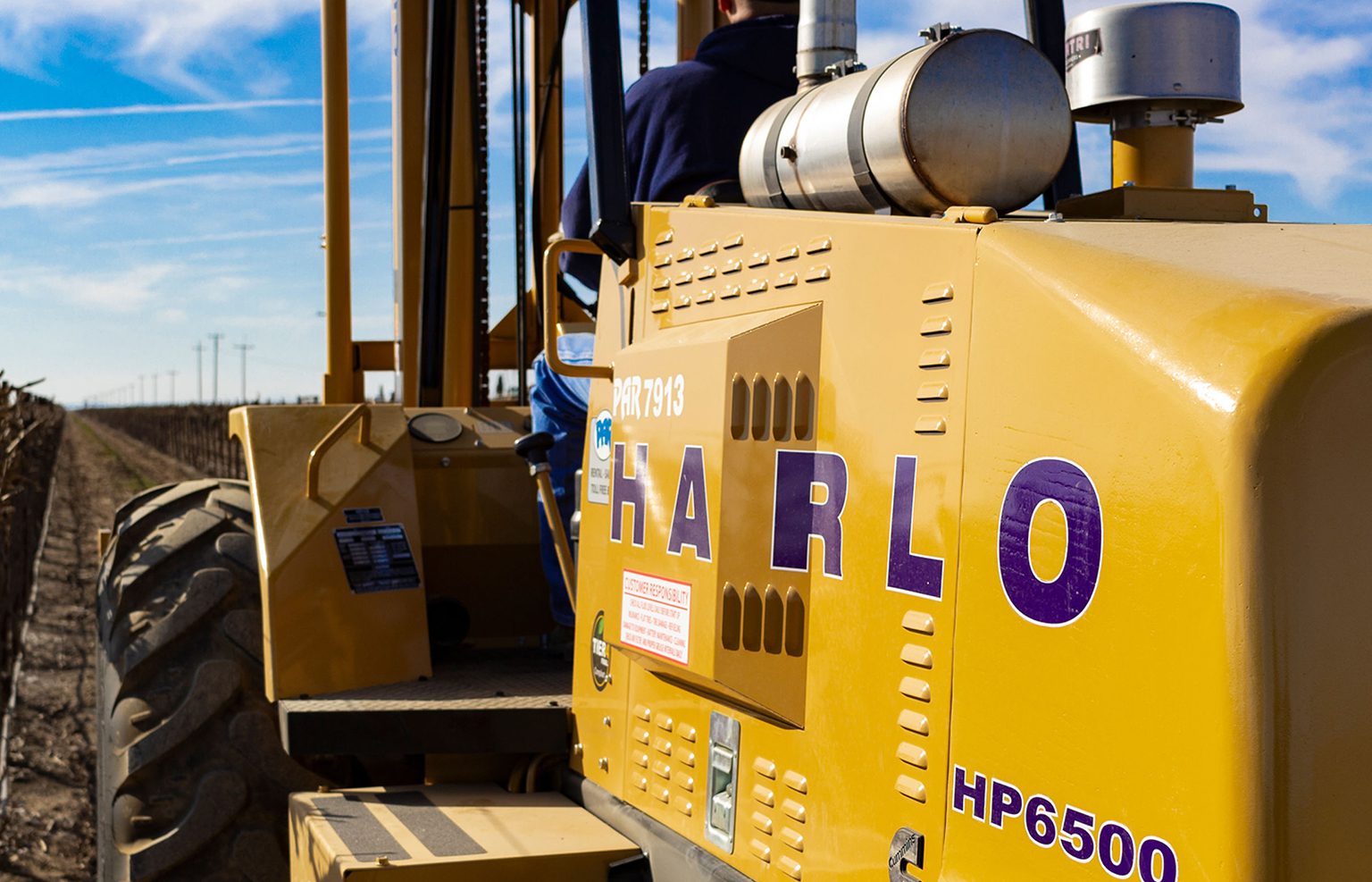 Harlo rough terrain forklift operating in a vineyard field